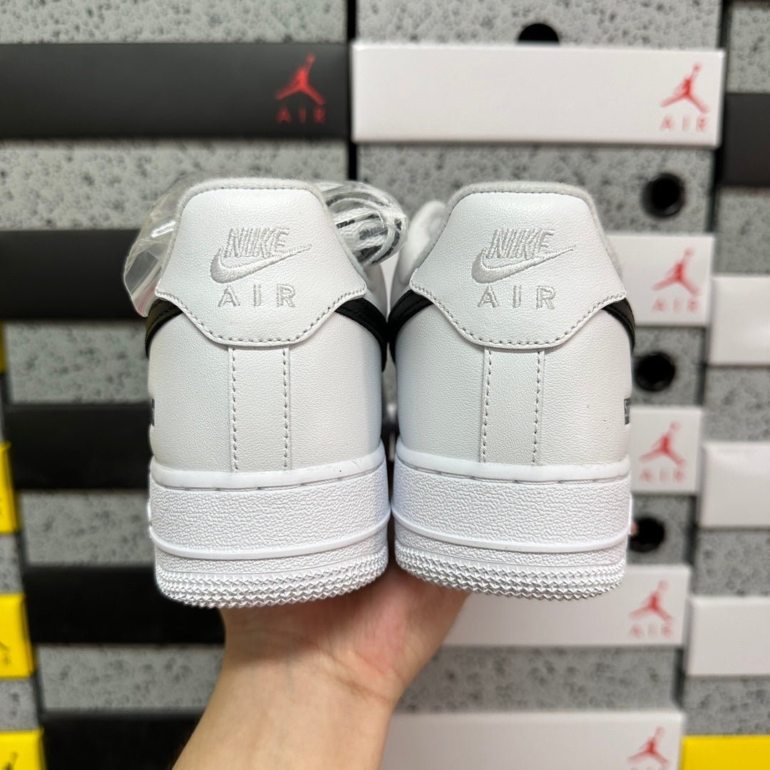 White low-top sneakers with Air-branded heel tabs, rear view
