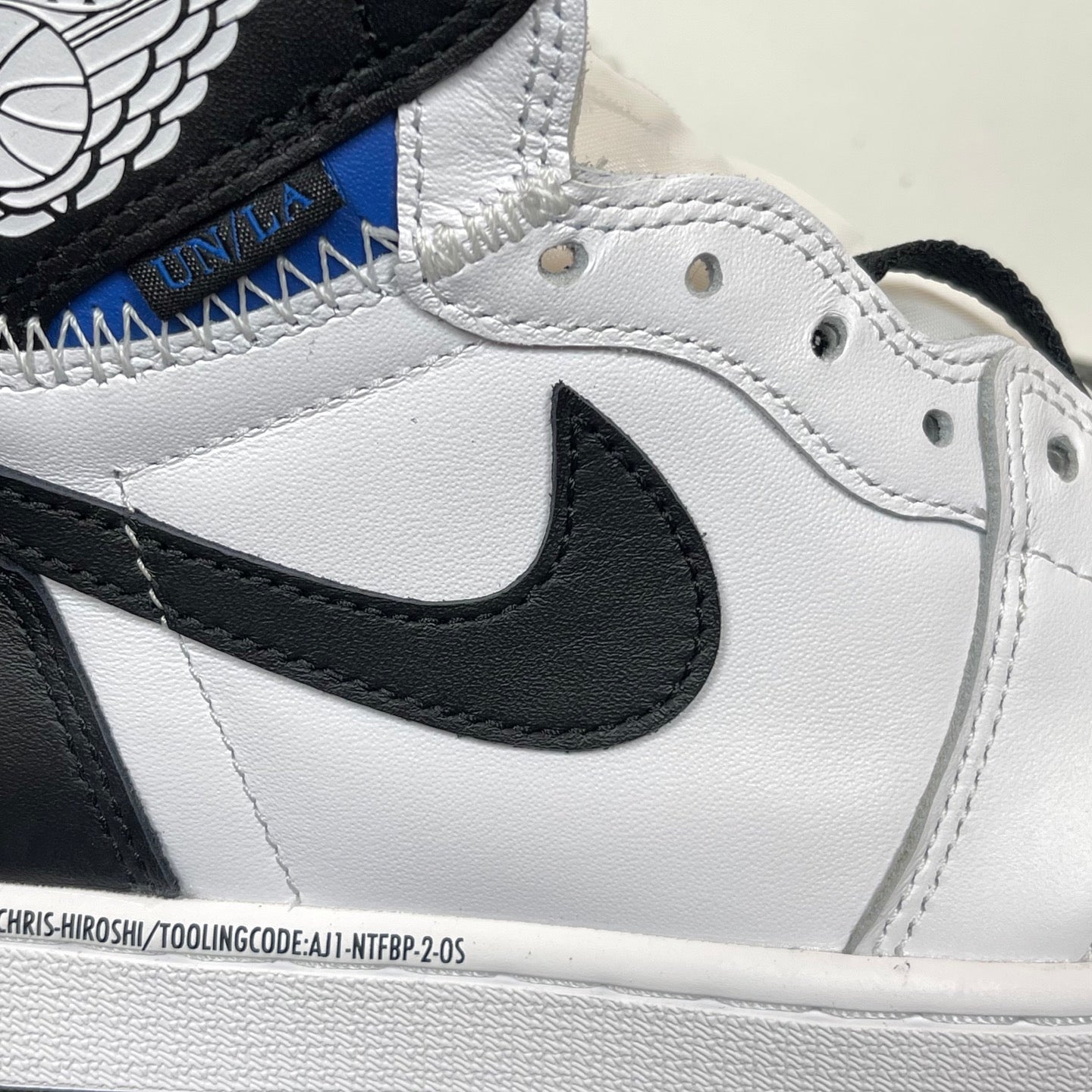Close-up of white high-top sneakers with black Nike Swoosh and textured stitching