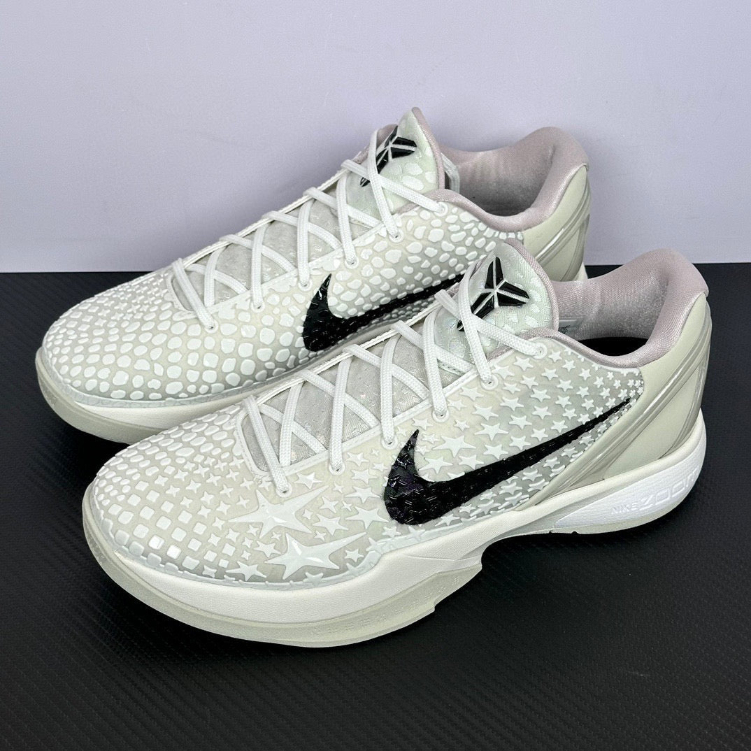 Pair of low-top sneakers angled view, white star upper, black swoosh, white laces