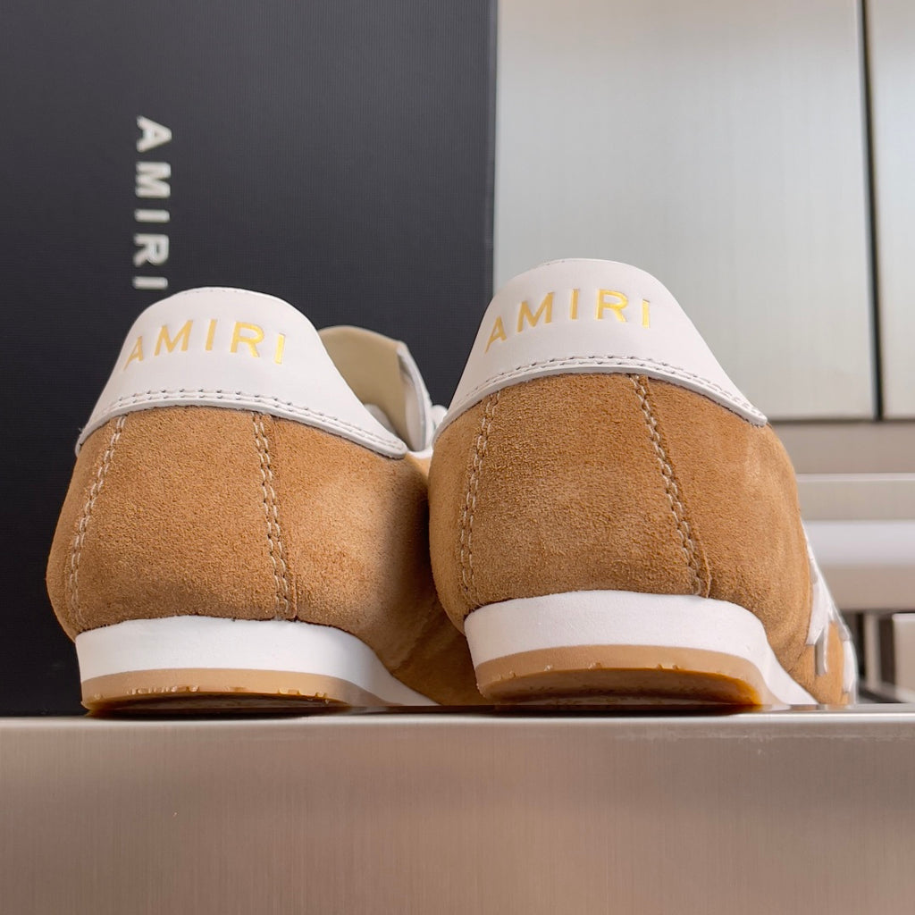Tan suede sneakers with white heel tabs showing AMIRI branding