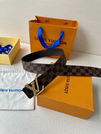 Louis Vuitton Damier check belt with silver V buckle laid across box and dust bag