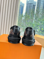 Back view of monogram slip-on shoes, brown upper with logo, black rubber soles