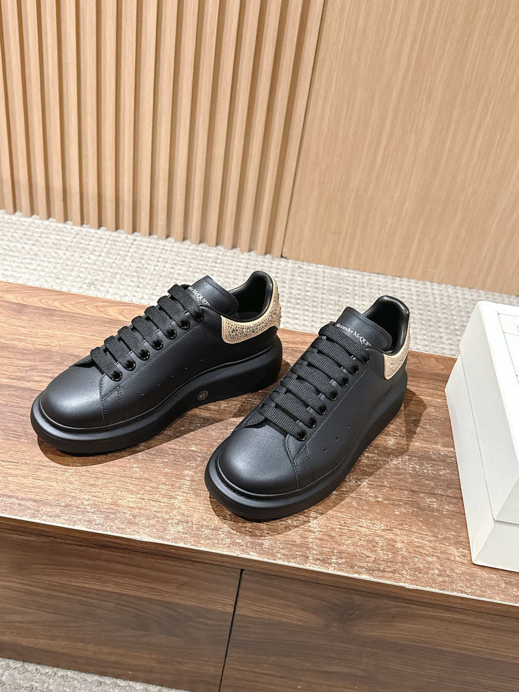 Black leather lace-up sneakers with gold glitter trim at the heel