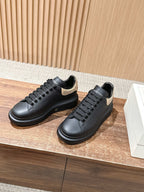 Black leather lace-up sneakers with gold glitter trim at the heel