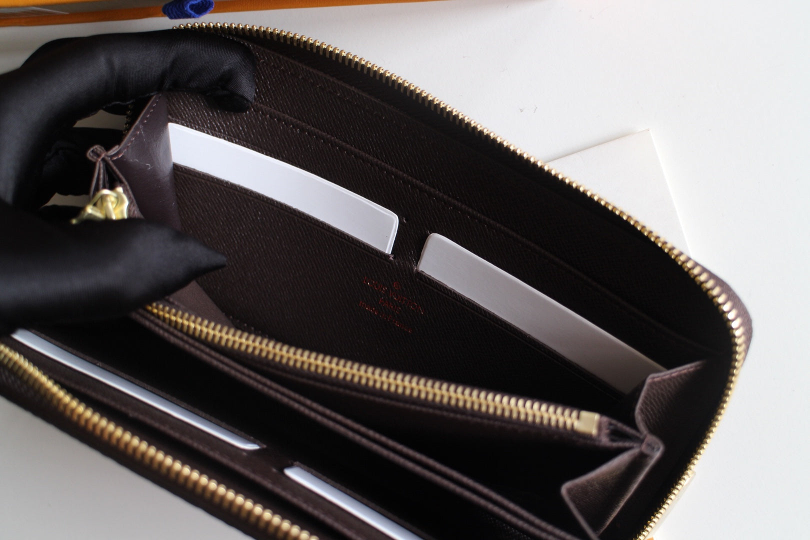 Louis Vuitton small bag interior with card slots and gold zipper track.