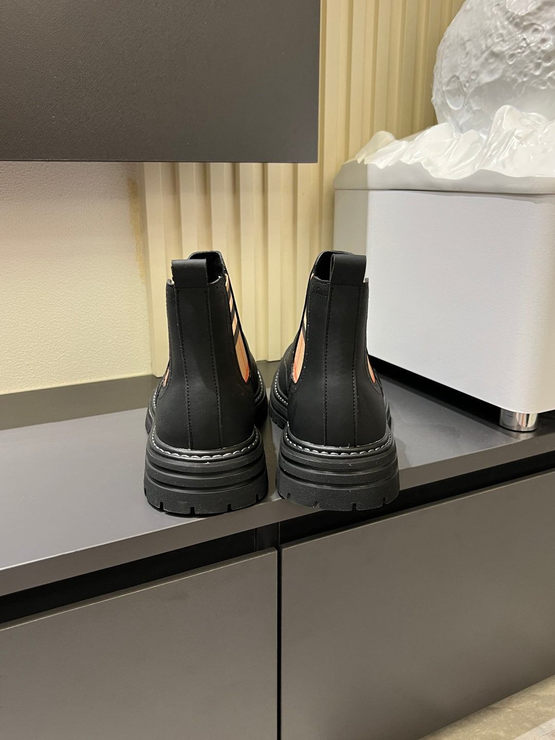 Black leather Chelsea boots with pull tabs and chunky stitched tread sole