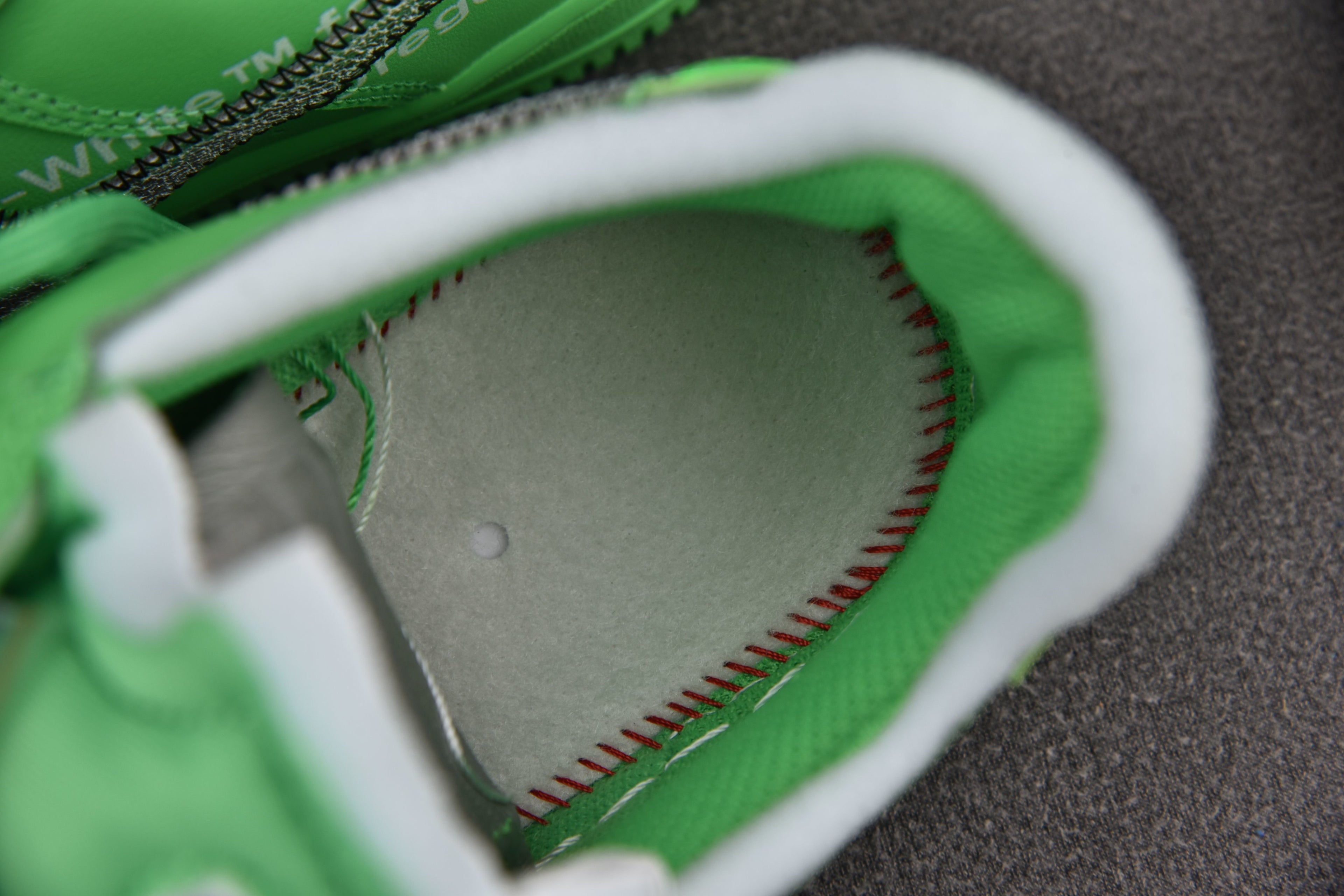 Green sneaker interior lining with white trim and visible stitching detail