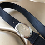 Prada belt close-up of silver buckle with embossed strap end and dark leather