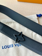 Close-up of navy leather belt with star-shaped engraved buckle and edge stitching