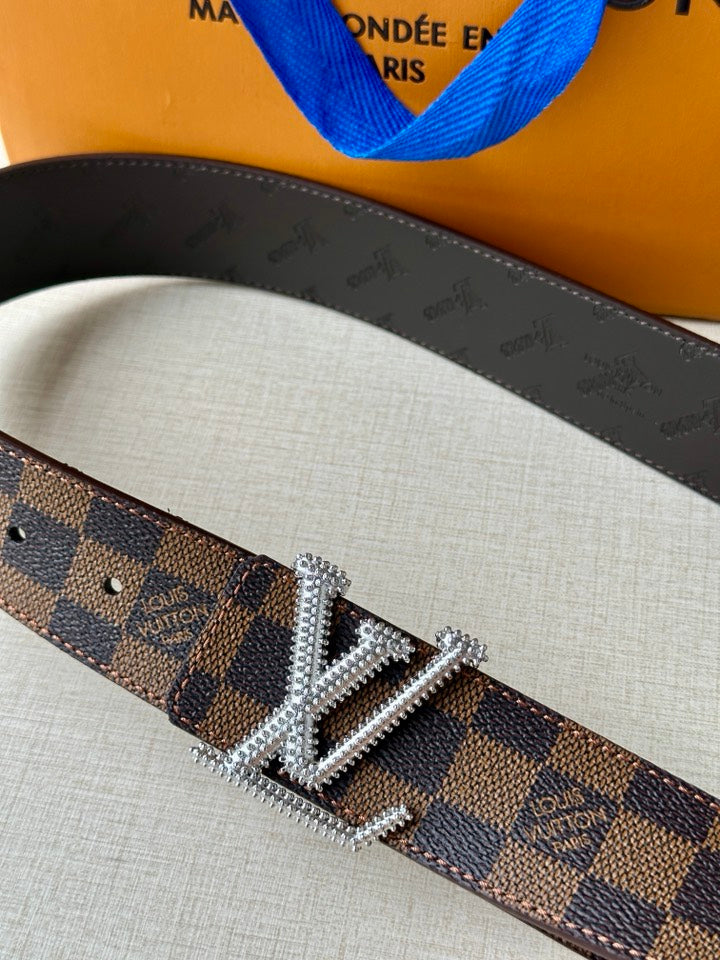 Louis Vuitton belt buckle close-up with silver V hardware on Damier check strap