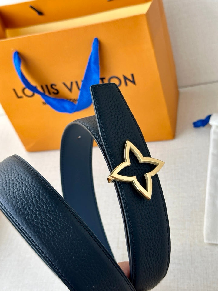 Louis Vuitton leather belt close-up with dark blue strap and gold star buckle