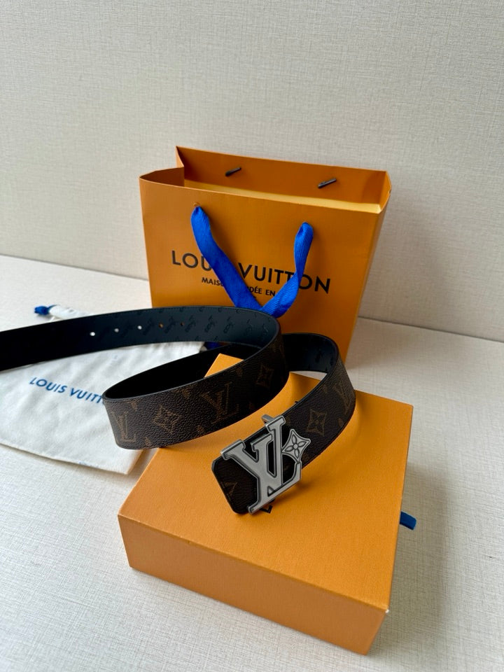 Louis Vuitton monogram belt angled view, dark strap with prominent gold buckle