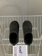 Balenciaga black suede slip-on sandals, underside view of two shoes