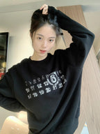 Black crewneck sweatshirt with white number and '6' graphic print on model