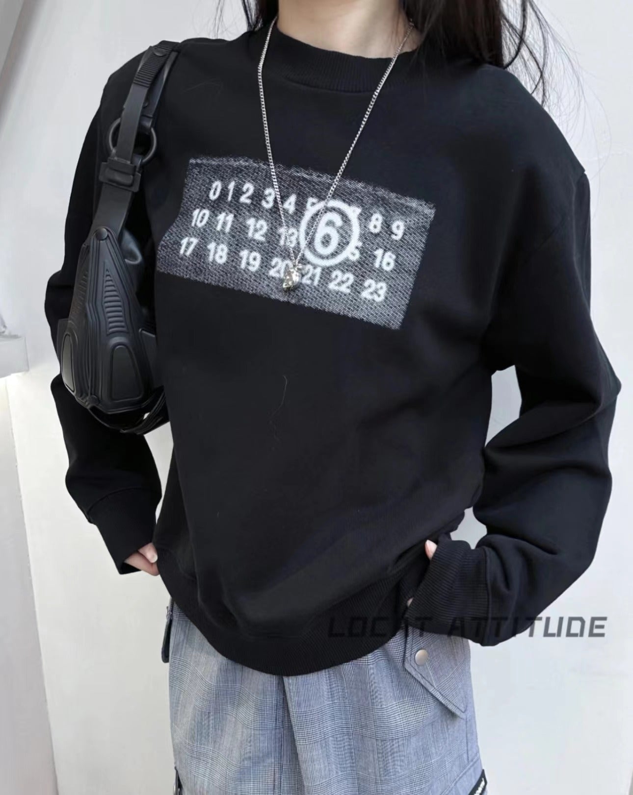 Black crewneck sweatshirt with square number logo worn by model