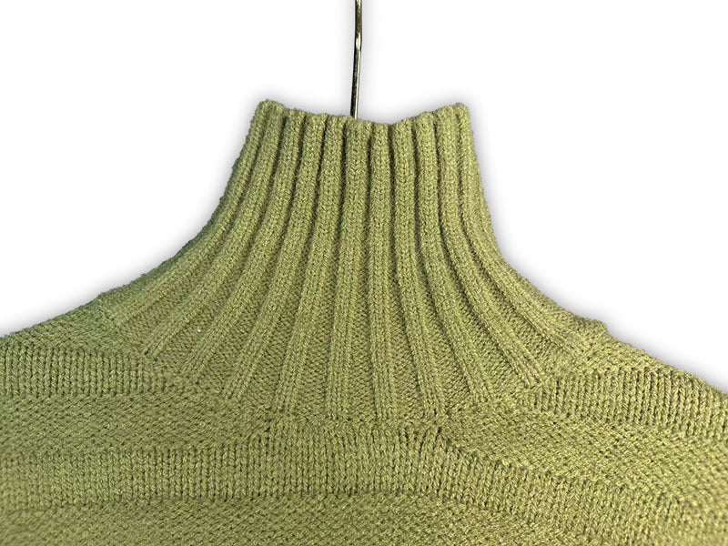 Bright green turtleneck knit sweater, close-up of ribbed collar and knit texture