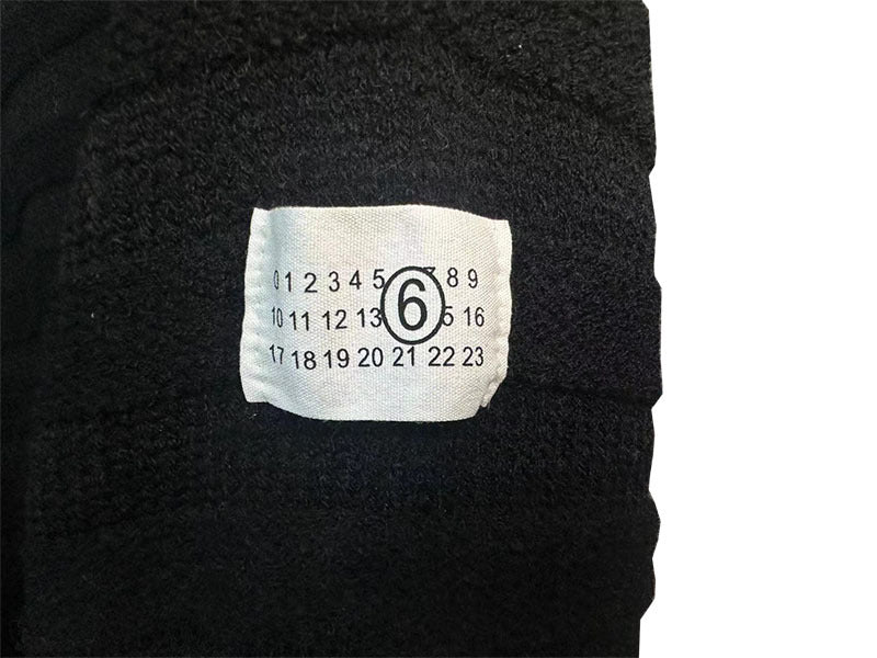 Dark charcoal knit sweater with size label on front