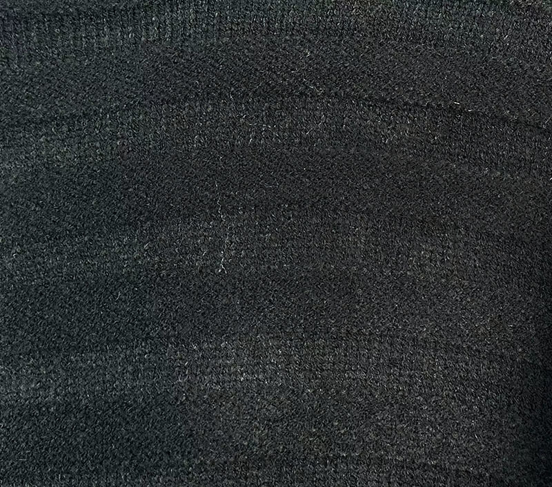 Dark charcoal knit fabric close-up with speckled texture