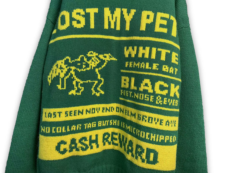Green knit sweater with yellow logo bands and “CASH REWARD” text