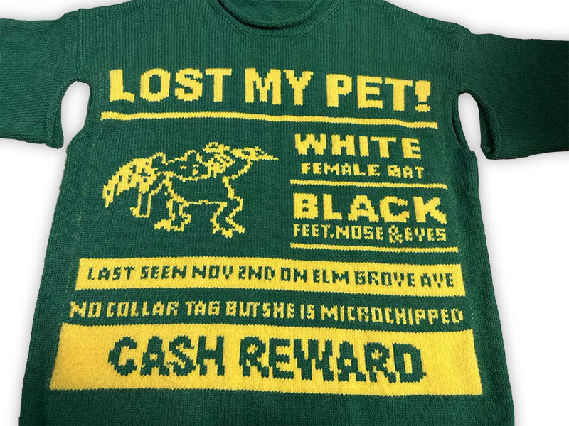 Green knit sweater with “LOST MY PET?” graphic and yellow “CASH REWARD” panel