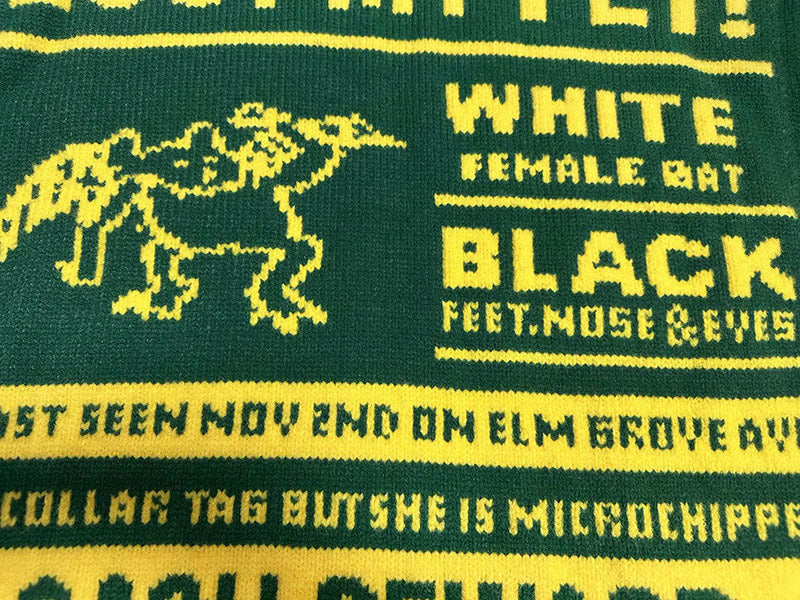 Green knit sweater with yellow dog graphic and “WHITE”/“BLACK” text