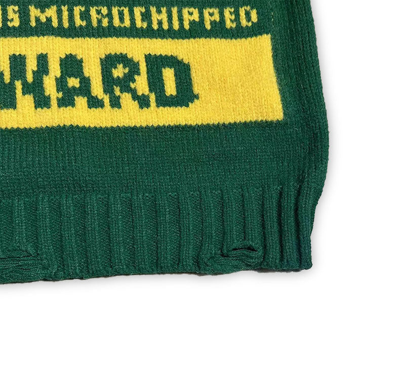 Green knit sweater closeup with yellow stripe and ribbed cuff hem