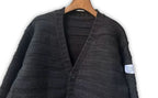 Maison Margiela dark cardigan close-up: V-neck, button front, ribbed knit and sleeve label