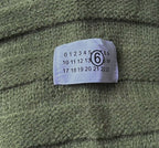 Olive green knit fabric with size label sewn near the chest