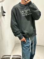 Dark crewneck sweatshirt with chest graphic, long sleeves