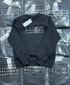 Navy crewneck sweatshirt with numbered ring graphic, flat lay