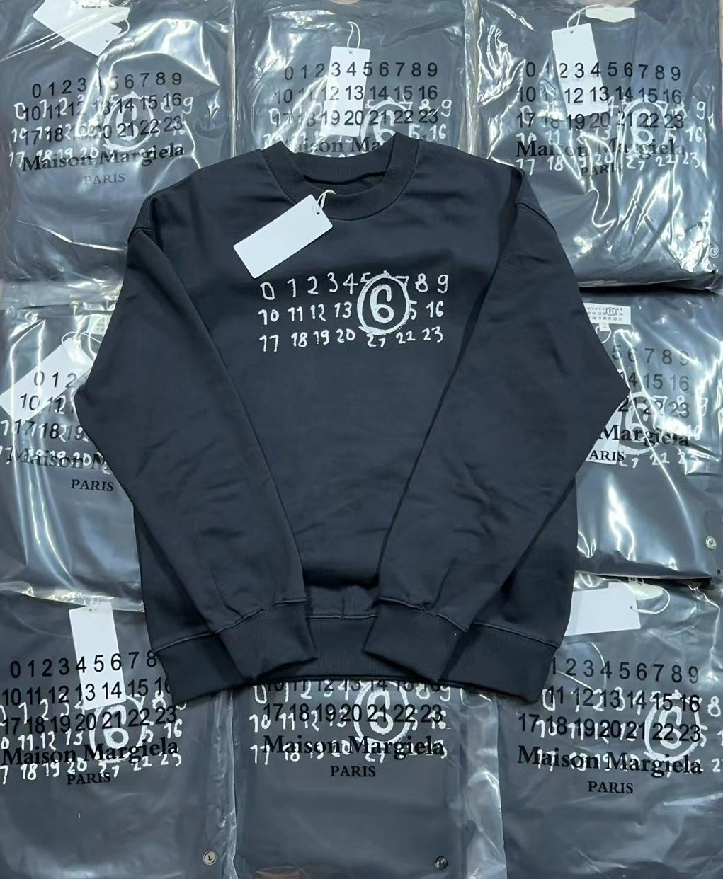 Navy crewneck sweatshirt with numbered ring graphic, flat lay