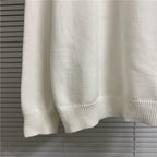 Cream knit sweater hem and cuffs with ribbed band at bottom