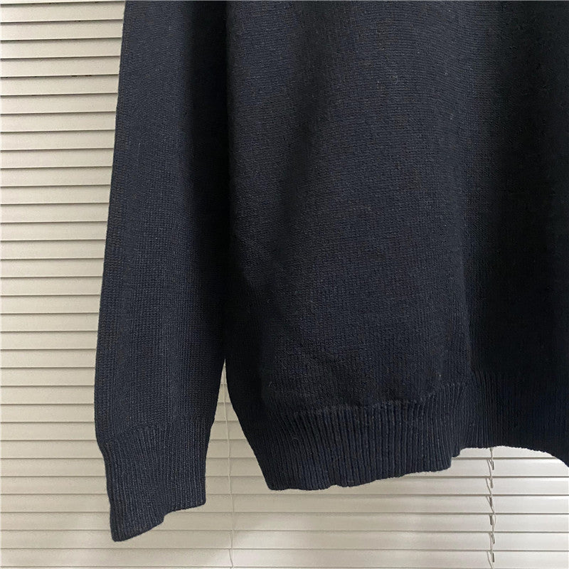Navy knit sweater with long sleeves, ribbed cuffs, and ribbed hem; plain front
