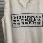Cream knit vest close-up of number and symbol patch on chest