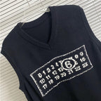 Navy knit vest close-up of V-neck and number graphic stripe patch