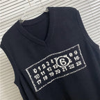 Dark sleeveless V-neck knit top with rectangular number-like graphic patch