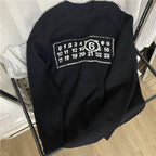 Black knit sweater with ribbed crew neck and white number logo graphic on chest