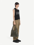 Black sleeveless V-neck knit top with rectangular graphic patch on chest