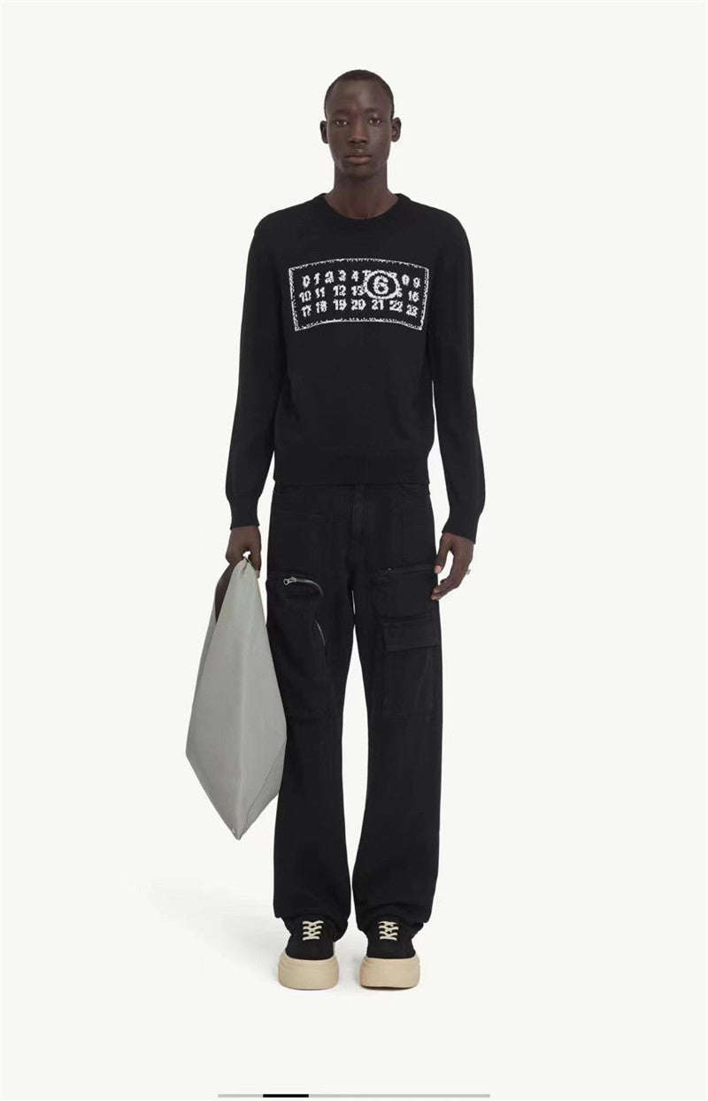 Black knit sweater with ribbed crew neck and number graphic chest, styled with black pants