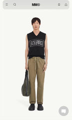 Black sleeveless V-neck knit top with rectangular graphic patch