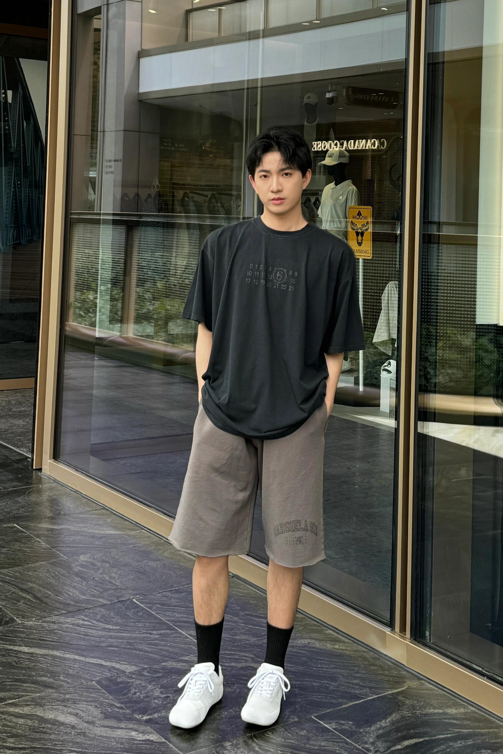 Maison Margiela dark crew-neck T-shirt with small chest logo graphic on model