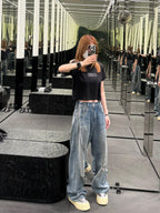 Black T-shirt with orange number graphic worn with light blue jeans