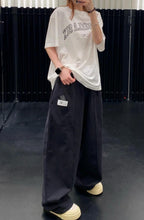Dark wide-leg trousers with elastic waistband, styled on model