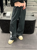 Dark gray-green wide-leg sweatpants with drawstring waist and side patch