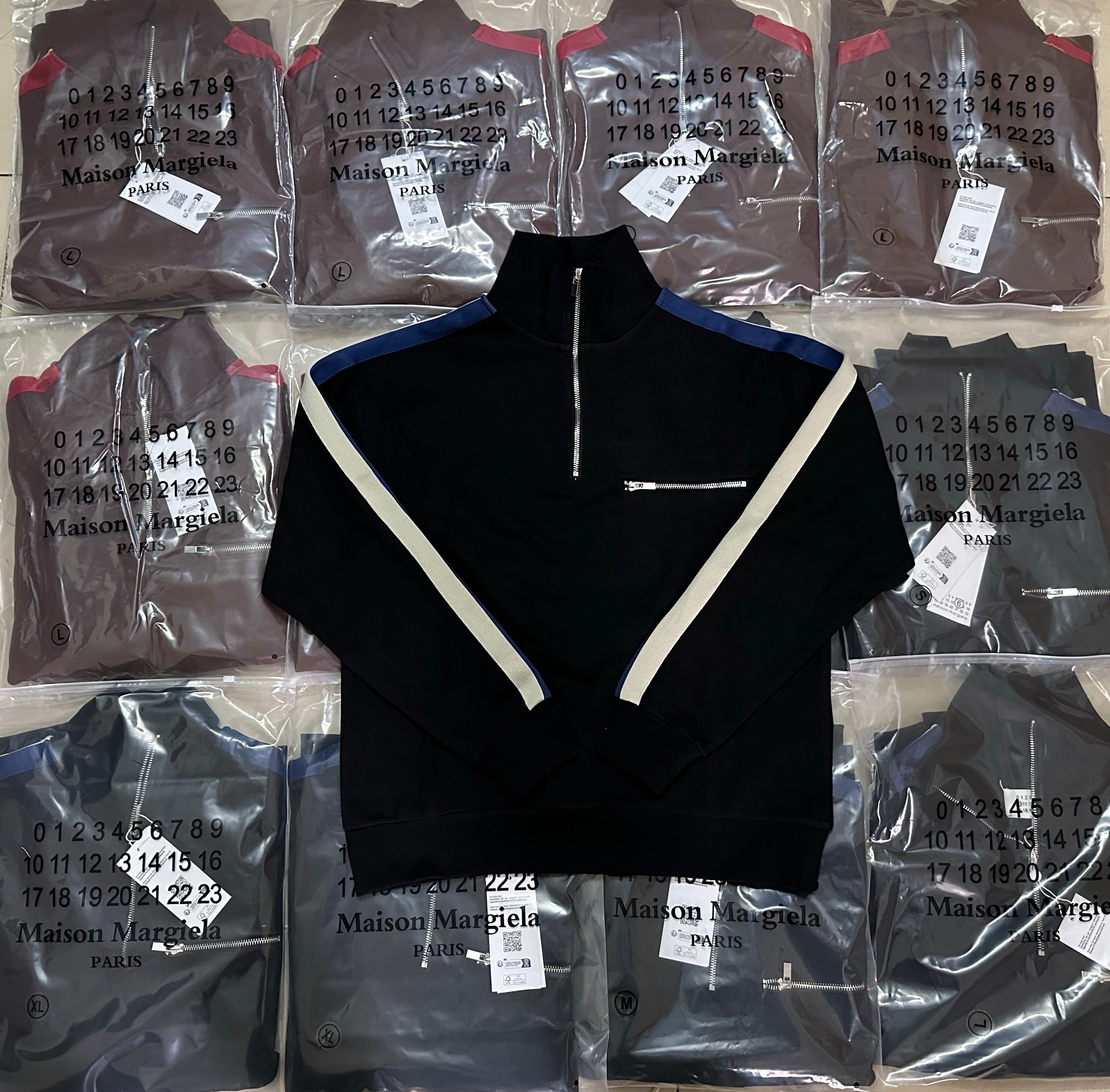 Black long-sleeve quarter-zip pullover with V-shaped white trim at the chest