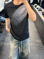 Black crewneck graphic T-shirt on model with light blue drawstring jeans