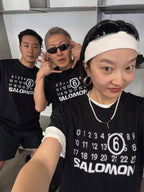 Black T-shirt with SALOMON number 6 graphic, worn by model