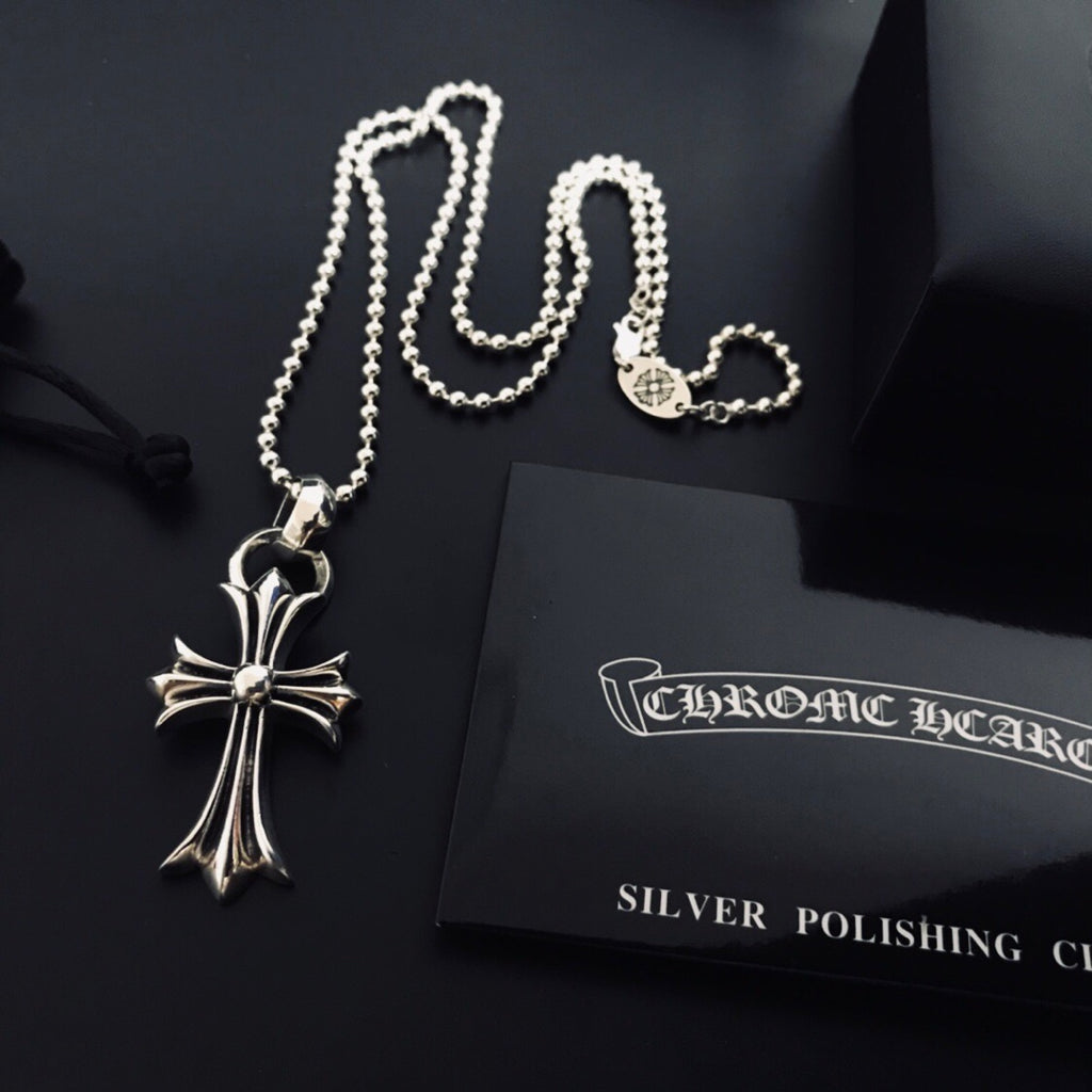 Silver cross pendant necklace with linked chain and cord closure loop