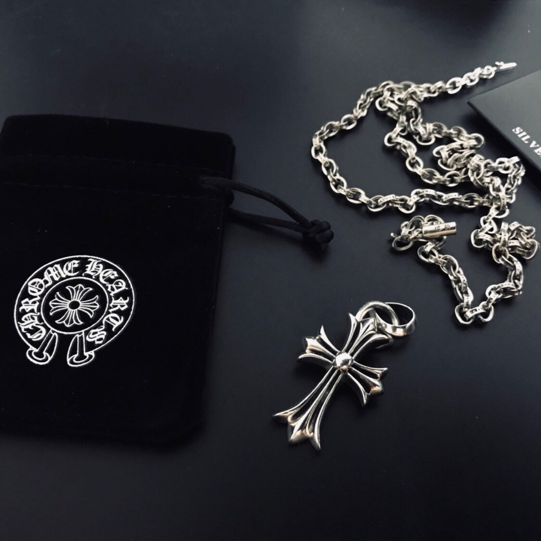 Silver cross pendant necklace with linked chain and black cord pouch