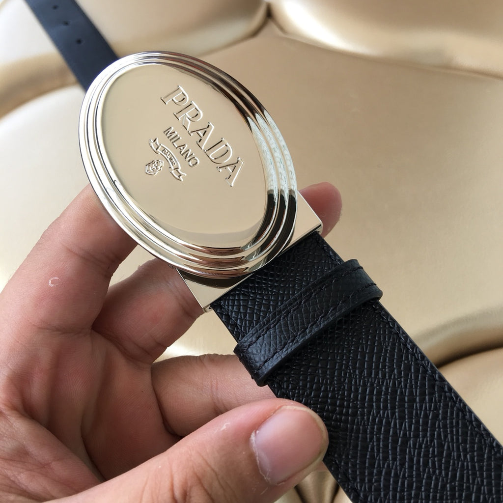 Prada belt buckle close-up with embossed branding on dark textured strap